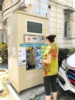 5月24日，瓊山區上丹花苑小區居民陳女士在使用共享凈水機取水。 本報記者 陳歆卓 攝